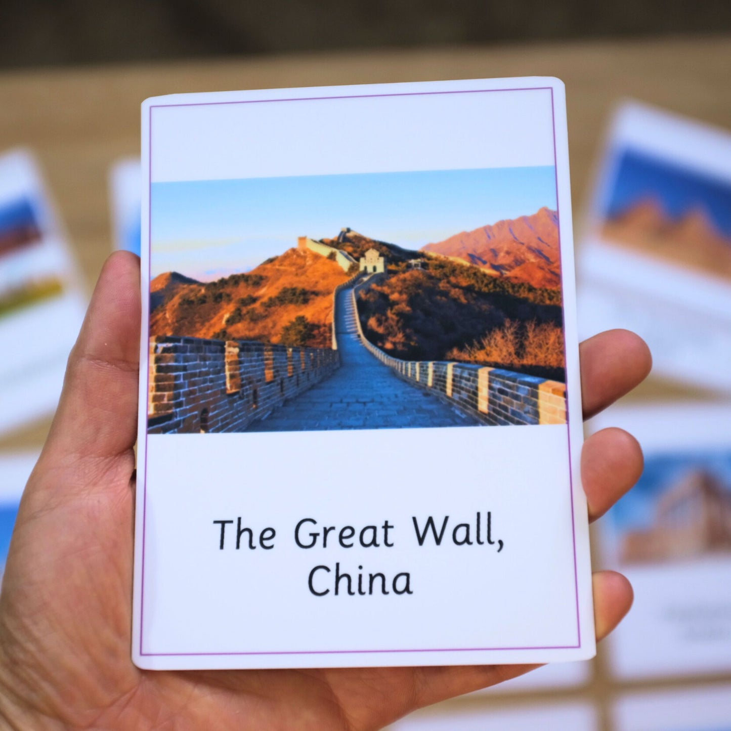 Card with an image of The Great Wall, China held by a hand.