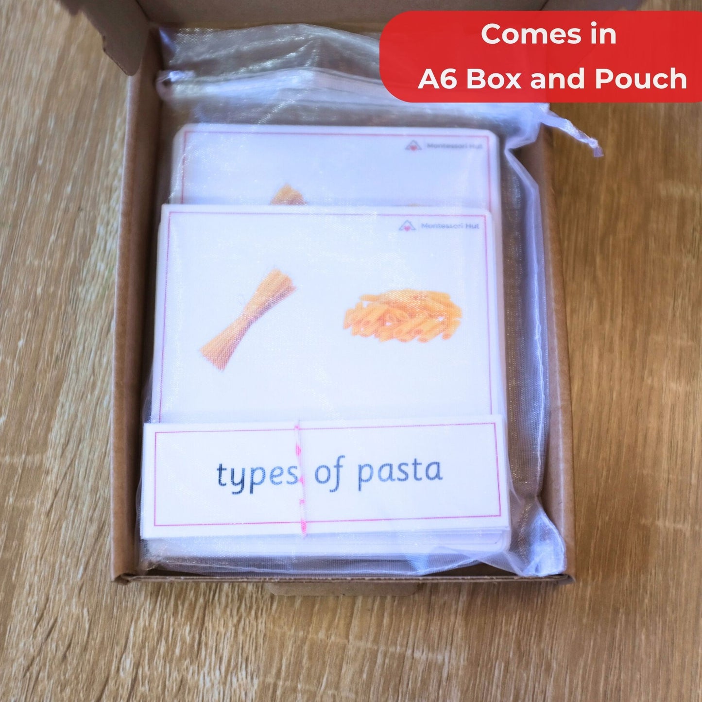 Card set titled 'Types of Pasta' in a box with a clear pouch on a wooden surface.
