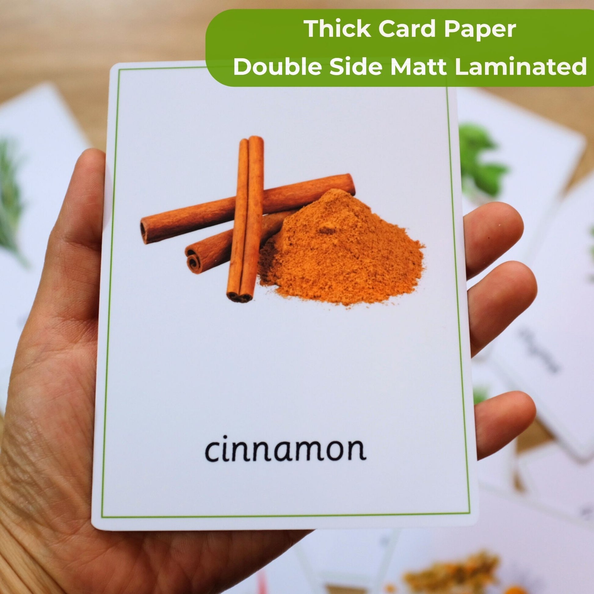 Card with cinnamon sticks and powder held by a hand, labeled 'cinnamon'.