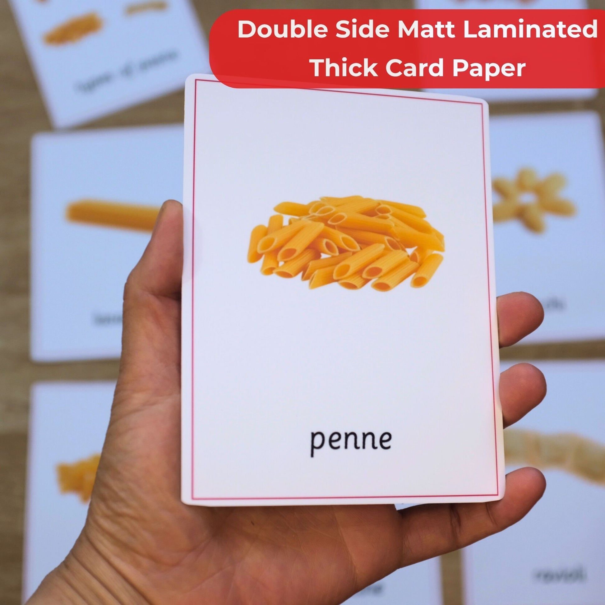 Card with penne pasta illustration held by a hand, on a background of more cards.